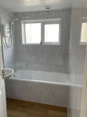 a bathroom with a tub and a sink and a window at House with stunning sea views in Downderry
