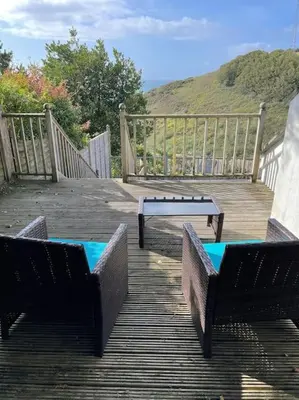 a table and two chairs on a wooden deck at House with stunning sea views in Downderry