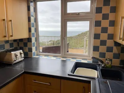 a kitchen with a sink and a window with a view at House with stunning sea views in Downderry