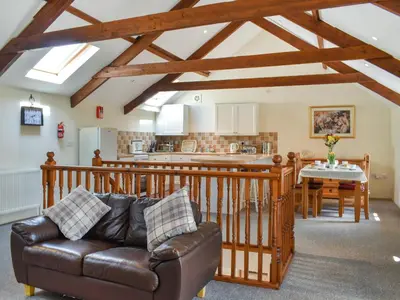 a living room with a leather couch and a kitchen at Skiber Spar in Davidstow