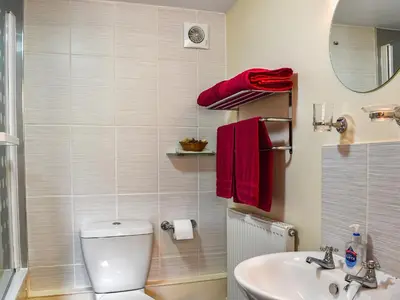 a bathroom with a toilet and a sink and red towels at Skiber Spar in Davidstow
