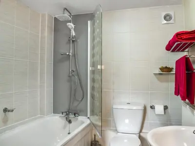a bathroom with a shower and a toilet and a sink at Skiber Spar in Davidstow