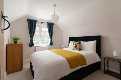 a bedroom with a bed with a yellow and white blanket at 4-Bed Cottage - Pets with Garden & Wood Burner in Helston