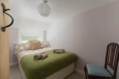 a bedroom with a bed with two stuffed animals on it at 4-Bed Cottage - Pets with Garden & Wood Burner in Helston