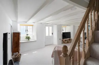 a living room with white walls and a staircase at 4-Bed Cottage - Pets with Garden & Wood Burner in Helston