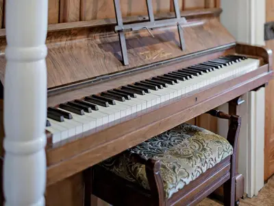 an old piano with a chair next to it at 4 Bed in St. Austell oc-82414 in Saint Stephen