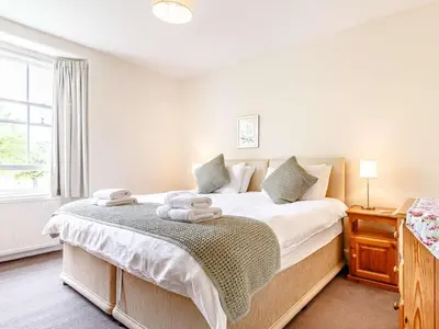a bedroom with a large bed with towels on it at 4 Bed in St. Austell oc-82414 in Saint Stephen