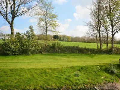 a field of green grass with trees in the background at 4 Bed in St. Austell oc-82414 in Saint Stephen
