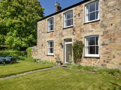a stone house with a lawn in front of it at 4 Bed in St. Austell oc-82414 in Saint Stephen