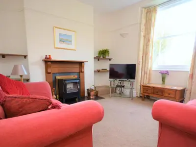 a living room with a red couch and a fireplace at 4 Bed in St. Austell oc-82414 in Saint Stephen