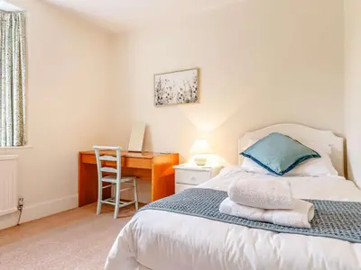 a bedroom with a bed with a desk and a chair at 4 Bed in St. Austell oc-82414 in Saint Stephen