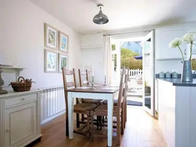 a dining room with a table and chairs in a kitchen at Castaway, Port Isaac Bay Holidays in Port Isaac