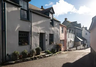 a row of white houses with potted plants on a street at Rosemary Cottage, Port Isaac Bay Holidays in Port Isaac