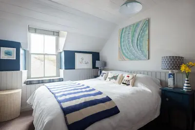 a blue and white bedroom with a bed and a window at Rosemary Cottage, Port Isaac Bay Holidays in Port Isaac