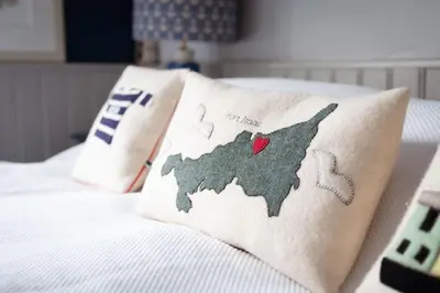 a pillow with a map of united states on a bed at Rosemary Cottage, Port Isaac Bay Holidays in Port Isaac