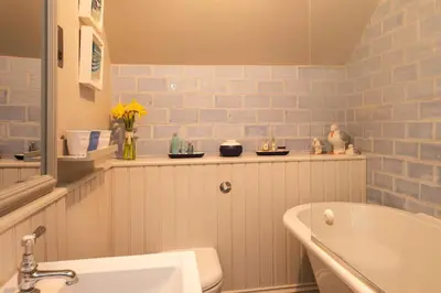 a bathroom with a white tub and a sink at Rosemary Cottage, Port Isaac Bay Holidays in Port Isaac