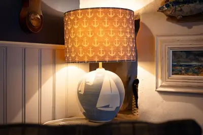 a lamp with a vase sitting on a table at Rosemary Cottage, Port Isaac Bay Holidays in Port Isaac