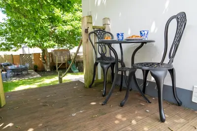 two chairs and a table on a patio at Stunning 4 bedroom house in Wadebridge, Cornwall - 2 living rooms and superking beds in Wadebridge