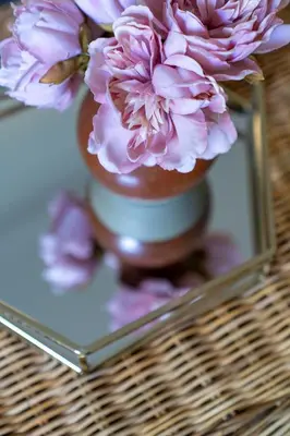 a reflection of a vase with pink flowers in a mirror at Stunning 4 bedroom house in Wadebridge, Cornwall - 2 living rooms and superking beds in Wadebridge