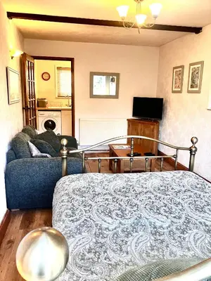 a living room with a bed and a couch at Apartment in lovely village in Newquay