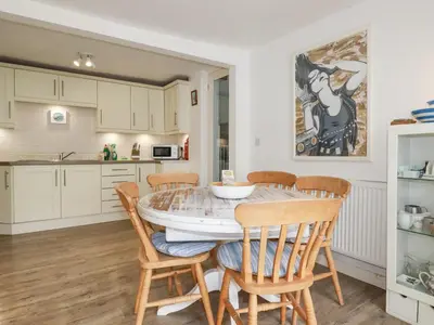 a kitchen and dining room with a table and chairs at Langurra in Newquay