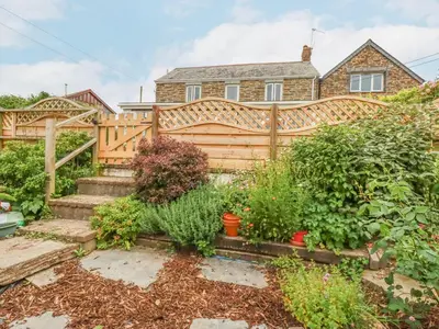 a garden in front of a wooden fence at Langurra in Newquay