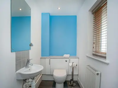 a bathroom with a white toilet and a sink at Villa Gallery-77 in Perranwell