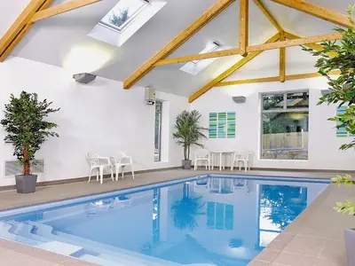 a swimming pool in a house with wooden beams at Villa Gallery-77 in Perranwell
