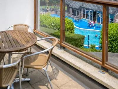 a patio with a table and chairs and a swimming pool at Villa Gallery-77 in Perranwell