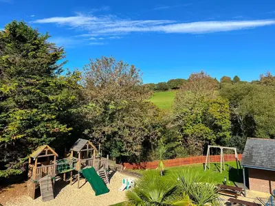 a playground with a slide and a swing set at Villa Gallery-77 in Perranwell