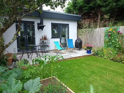 a patio with two chairs and a table in a yard at Hygga in Fowey