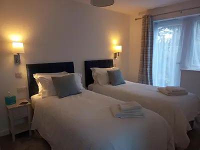 two beds in a hotel room with towels on them at Hygga in Fowey