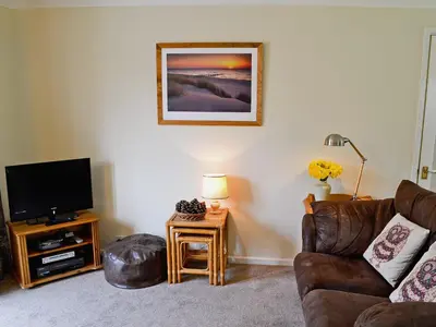 a living room with a couch and a television at Stone The Crows in Liskeard