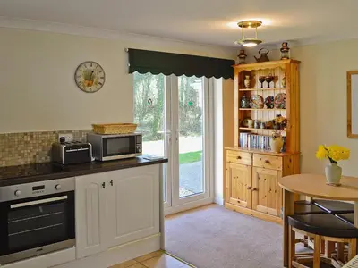 a kitchen with a counter with a microwave and a table at Stone The Crows in Liskeard