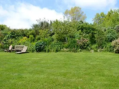 a park with two benches in a grass field at Grain Store 1 - 29635 in Portloe