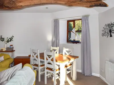 a living room with a table and chairs and a couch at Grain Store 1 - 29635 in Portloe