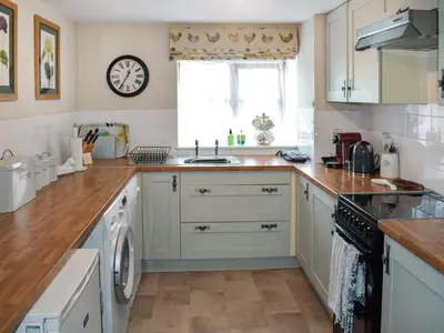 a kitchen with white cabinets and a window at Grain Store 1 - 29635 in Portloe