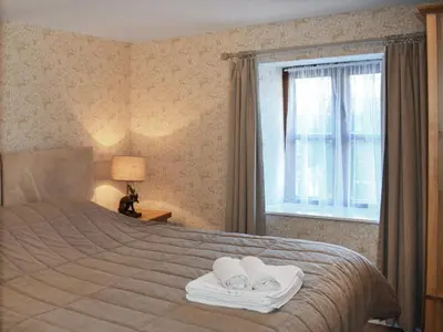 a bedroom with a bed with towels and a window at Grain Store 1 - 29635 in Portloe