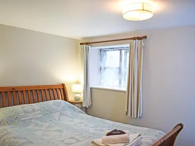 a bedroom with a bed and a window at Grain Store 2 - 29636 in Portloe