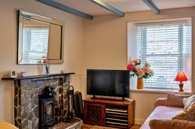 a living room with a fireplace and a television at Finest Retreats - Greenbank in Saint Dennis