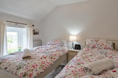 a bedroom with two twin beds and a window at Finest Retreats - Greenbank in Saint Dennis