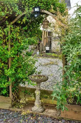an archway with a bird bath in a garden at Finest Retreats - Greenbank in Saint Dennis