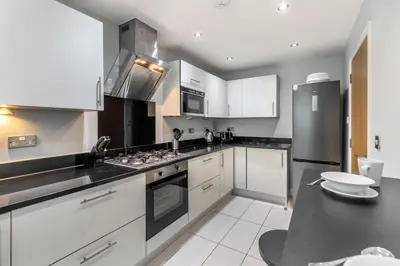 a kitchen with white cabinets and a stove top oven at The Glades - Retallack in Saint Columb Major