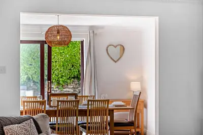 a dining room with a table and chairs and a heart on the wall at 4 Bed in Padstow oc-s29537 in Padstow