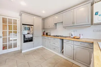 a white kitchen with white cabinets and appliances at 4 Bed in Padstow oc-s29537 in Padstow