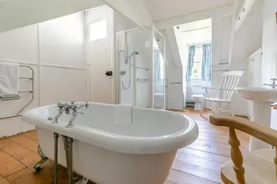 a white bathroom with a tub and a sink at 5 Bed in Trebetherick oc-b29371 in Polzeath