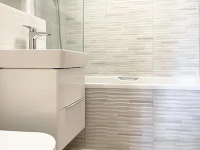 a white bathroom with a sink and a tub at Harvest Cottage in Padstow