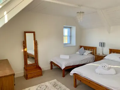 a bedroom with two beds and a mirror at Hillside in Port Isaac