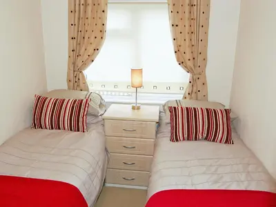 two beds in a room with a window at Rosewater Lodge in Saint Teath
