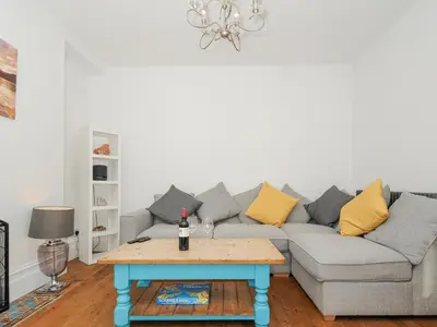 a living room with a couch and a table at Albert House in Looe